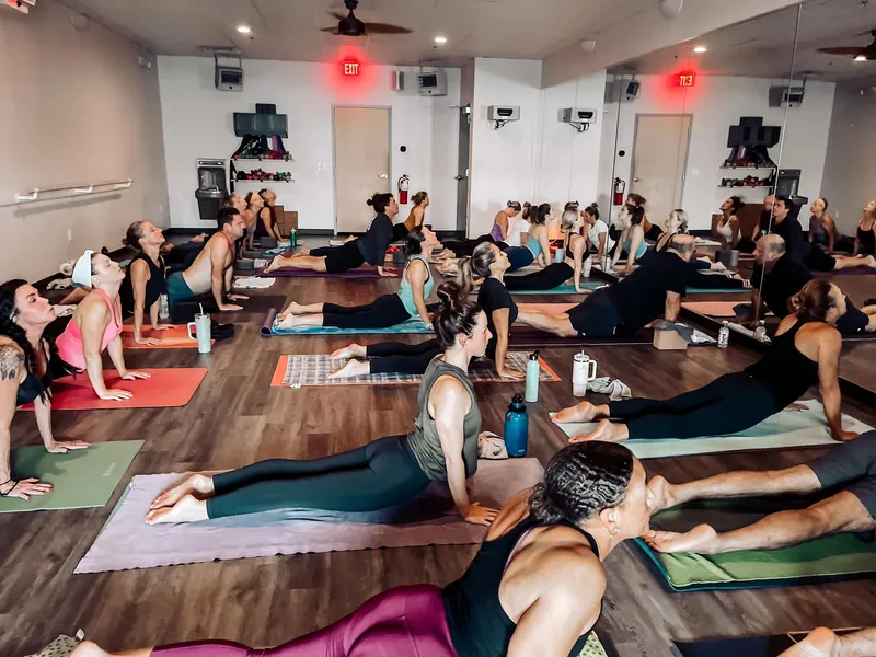 Full class practicing cobra pose at Sumit's Hot Yoga KC